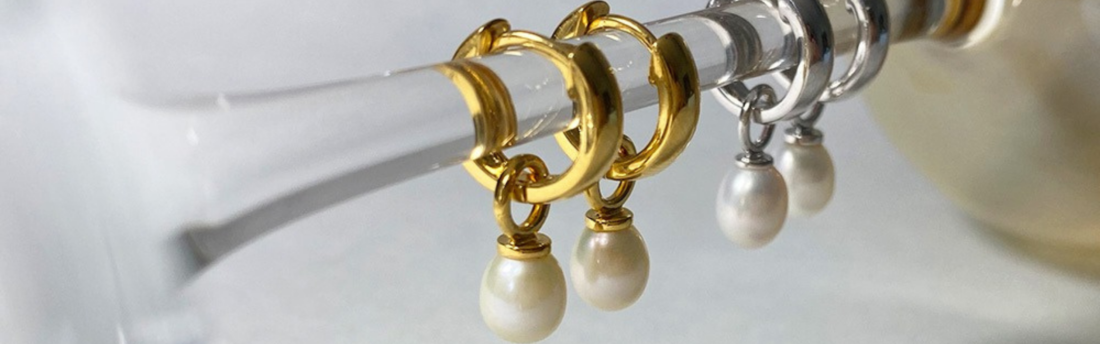 Picture of several hoop earrings with pearls on display made by Jersey Pearl