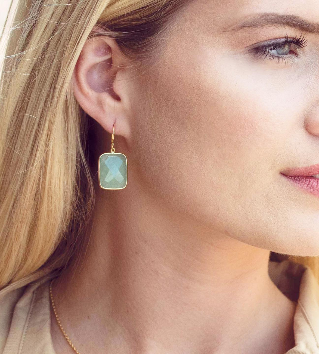 Model wears large green gemstone earrings by sarah alexander