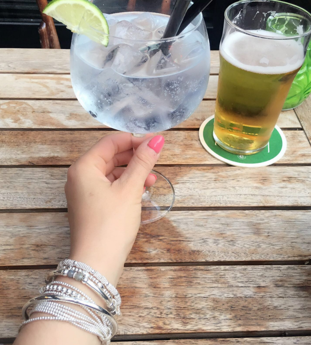 model wears annie haak bracelets and is reaching for an iced drink