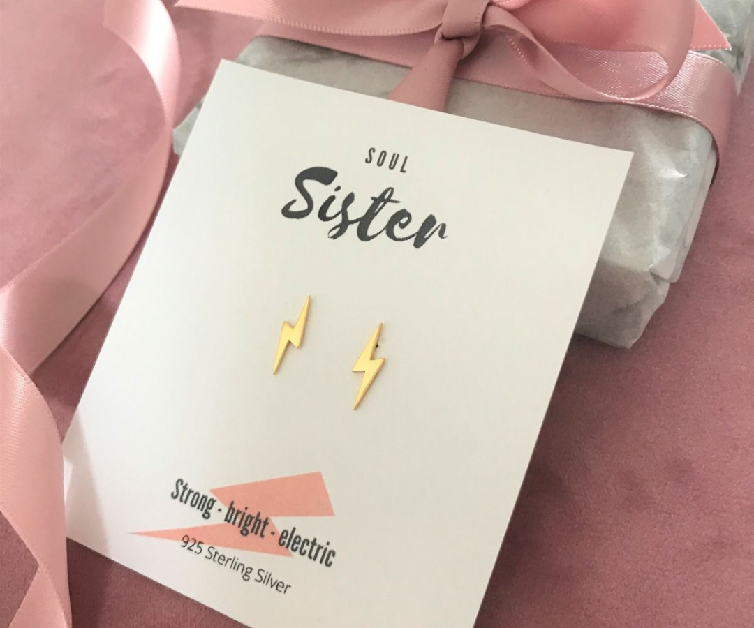 Photograph of gold lightning bolt stud earrings with gift message for blog on personalised jewellery