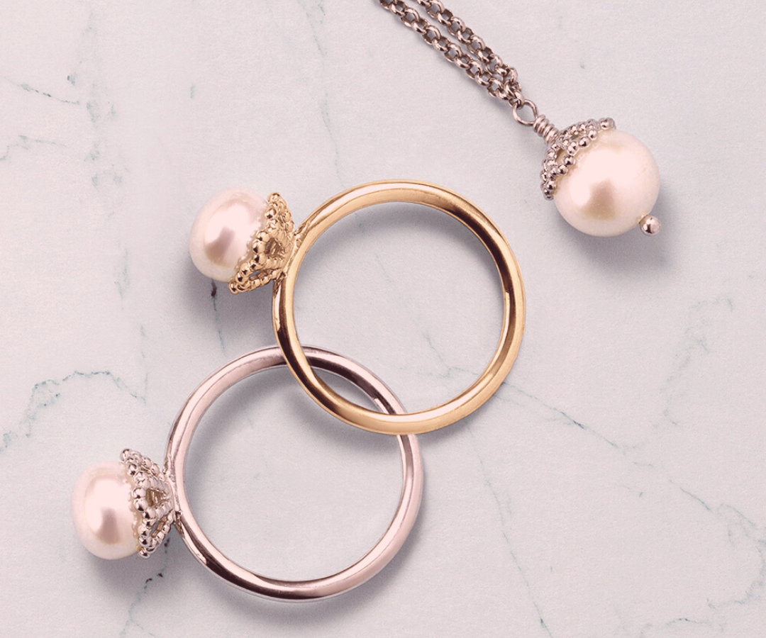 Photograph of two single pearl rings by Jersey Pearl and a single pearl pendant
