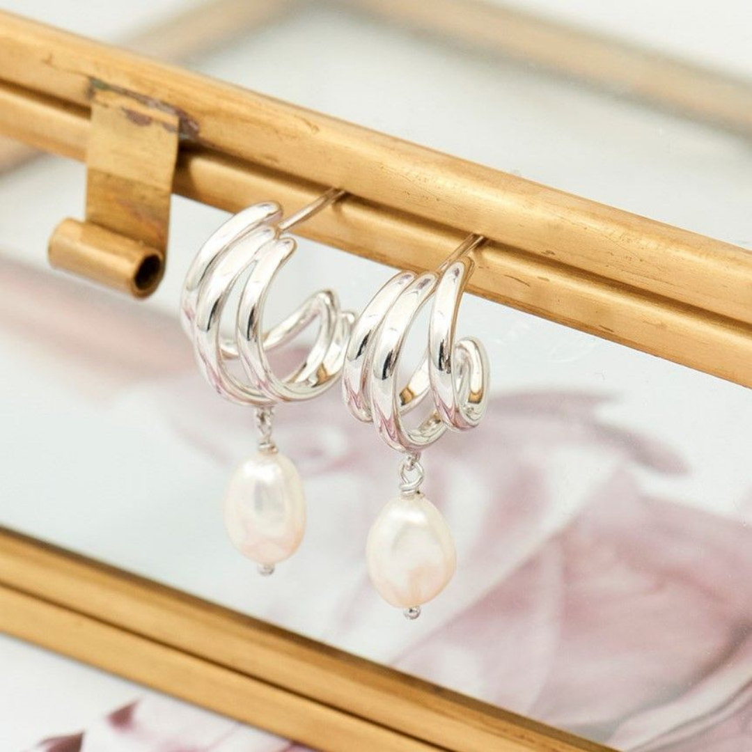 Photograph of a pair of ania haie silver earrings with pearl droplets