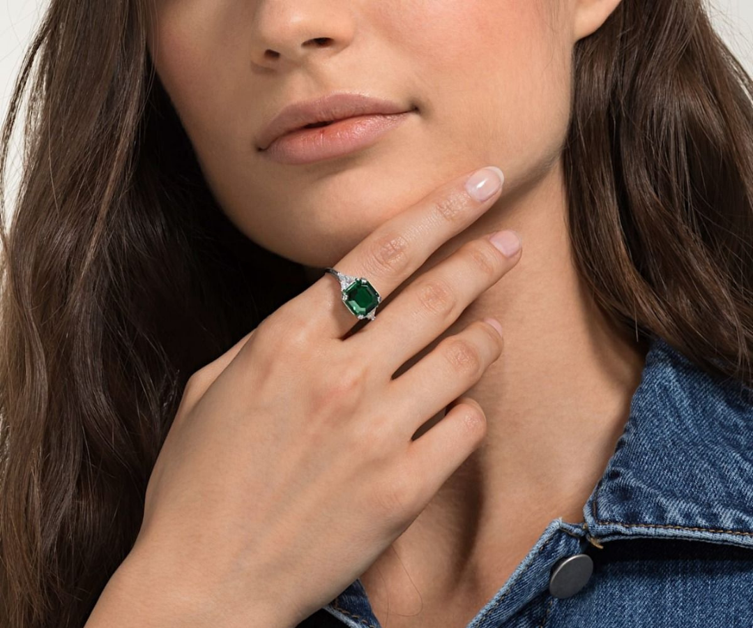 woman wearing a Swarovski cocktail ring with a green stone
