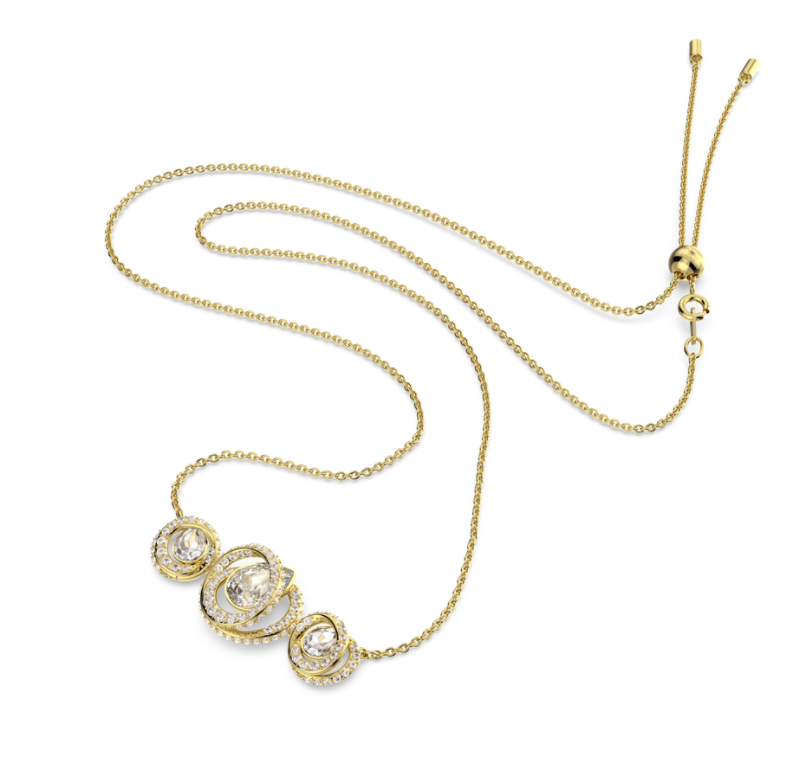 Photograph of a necklace by swarovski called Generation. It is gold with three spirals, each with a pear shaped crystal in the centre 