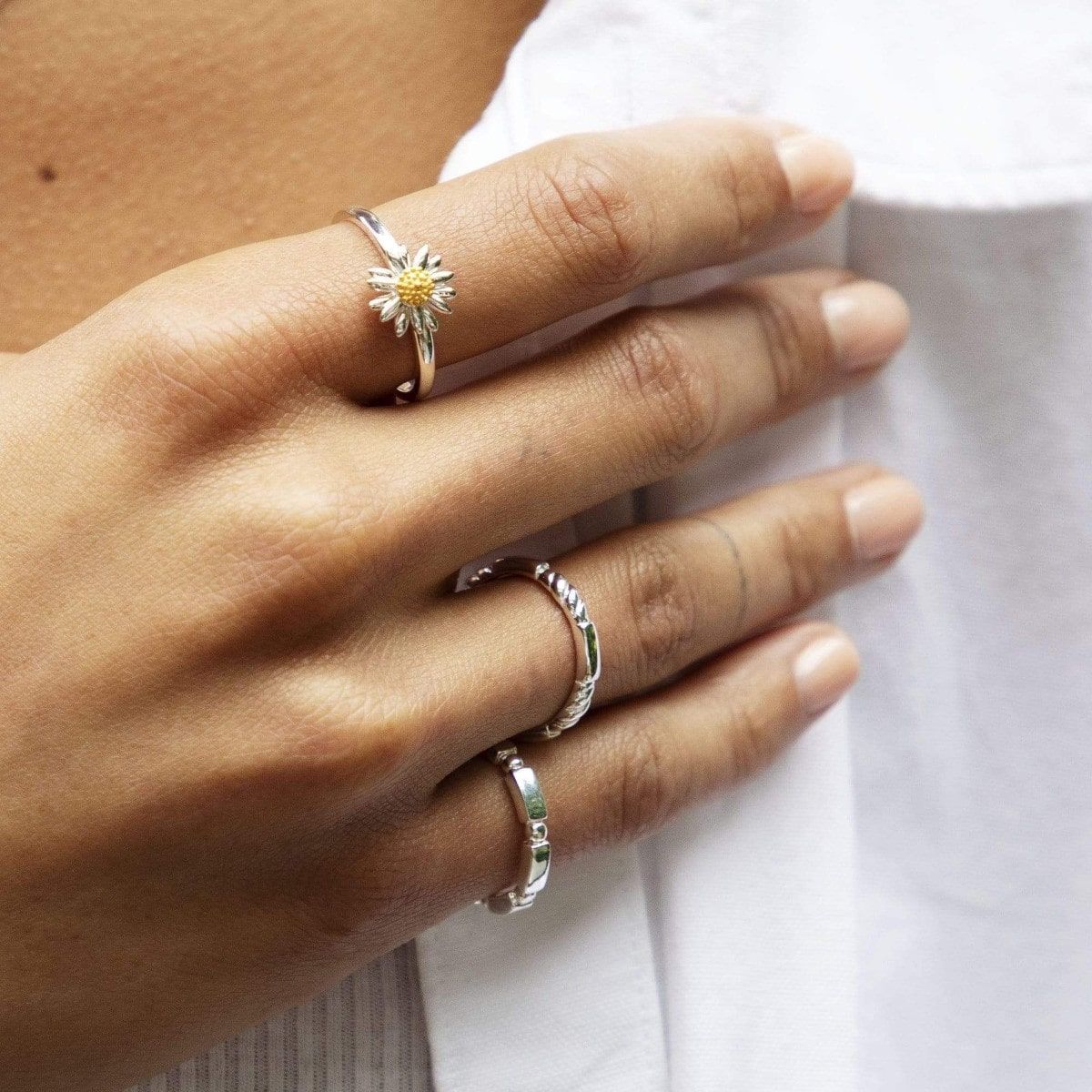 Woman's hand wearing daisy ring